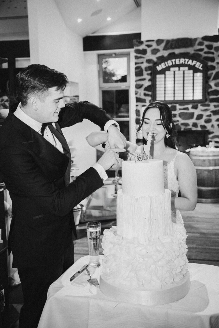 Brautpaar beim Anschneiden der Hochzeitstorte in Schwarzweiß