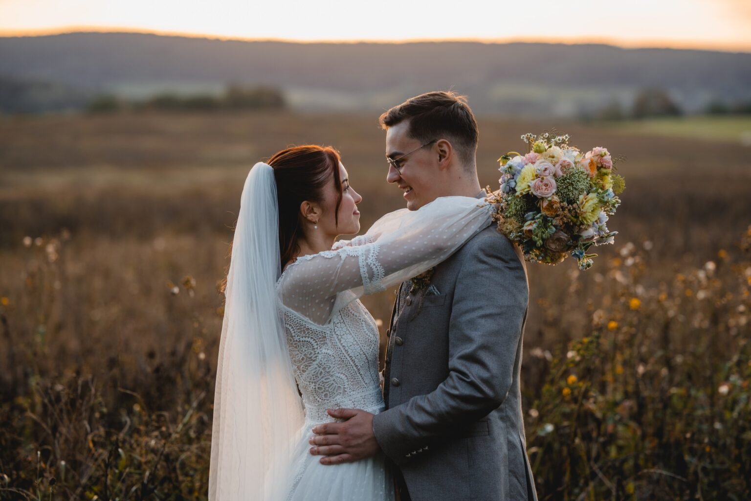 Brautpaar im warmen Abendlicht auf einem Feld – Hochzeitsfotografie im Ruhrgebiet