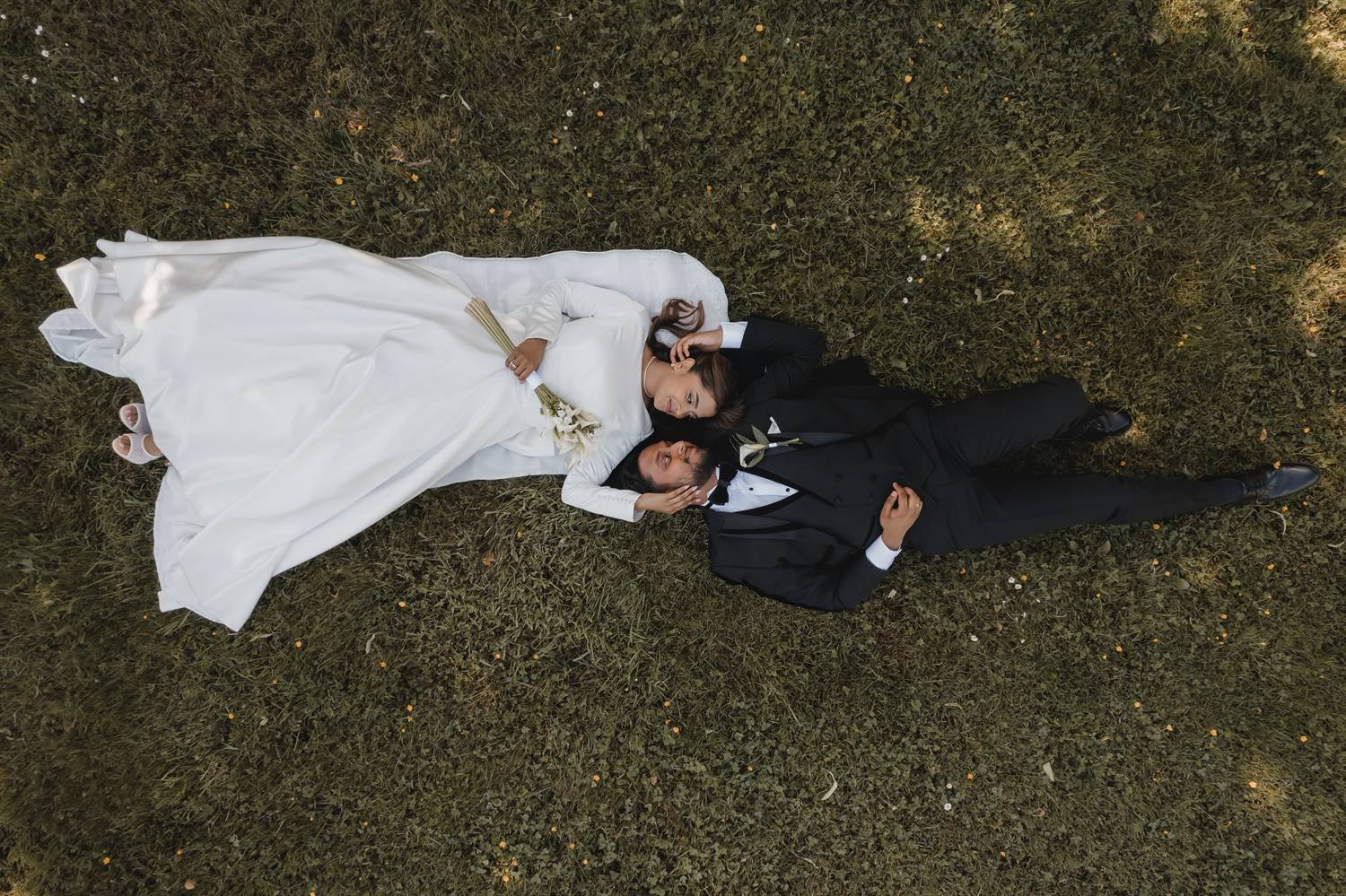 Brautpaar aus der Vogelperspektive im Gras – After-Wedding-Shooting von Aydin Genn