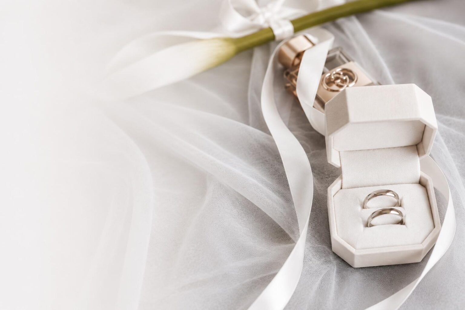 Eheringe in einer Schmuckschatulle auf Tüll und Satinband – Detailaufnahme zur Hochzeit